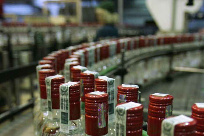 Bottles of vodka move along a conveyor belt