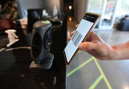 Co-owner Jenny Kovacs demonstrates how to check in with an app at Sonoma Fitness in Petaluma.