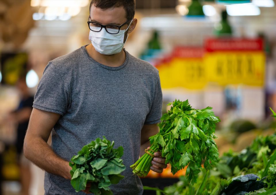 male wears medical mask against coronavirus while grocery shopping in supermarket or store