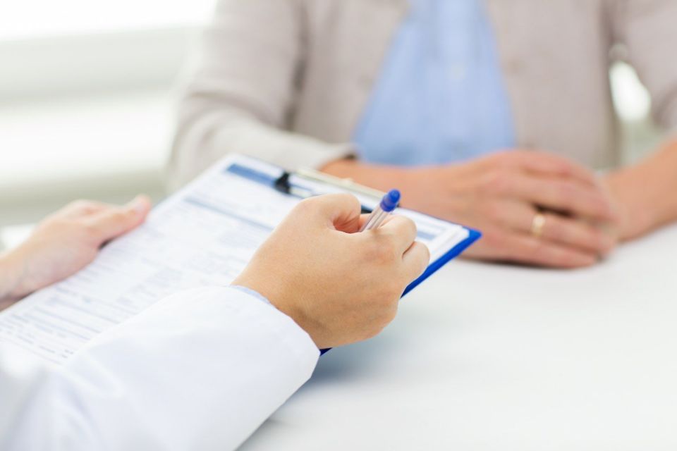 senior woman and doctor hands with clipboard meeting in medical office